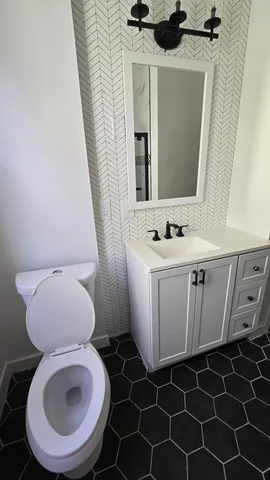 a bathroom with a toilet a sink and a mirror