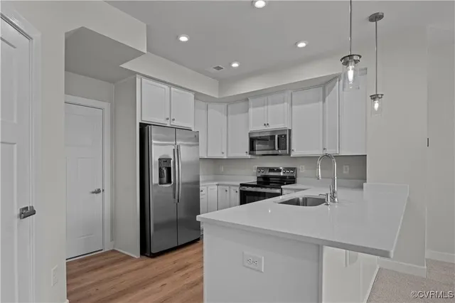 a kitchen with stainless steel appliances granite countertop a sink a stove a microwave and cabinets