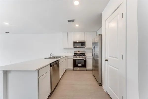 a kitchen with kitchen island sink stove and refrigerator
