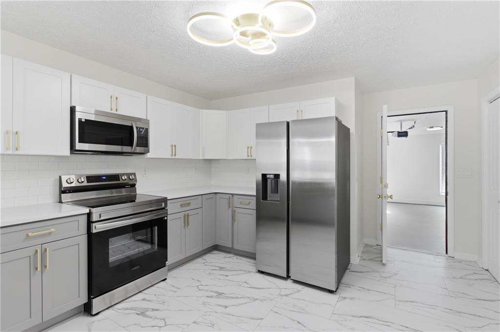 3760 Mountain Cove Road Snellville, GA 30039 - Photo 24 of 73 a kitchen with a refrigerator stove and microwave