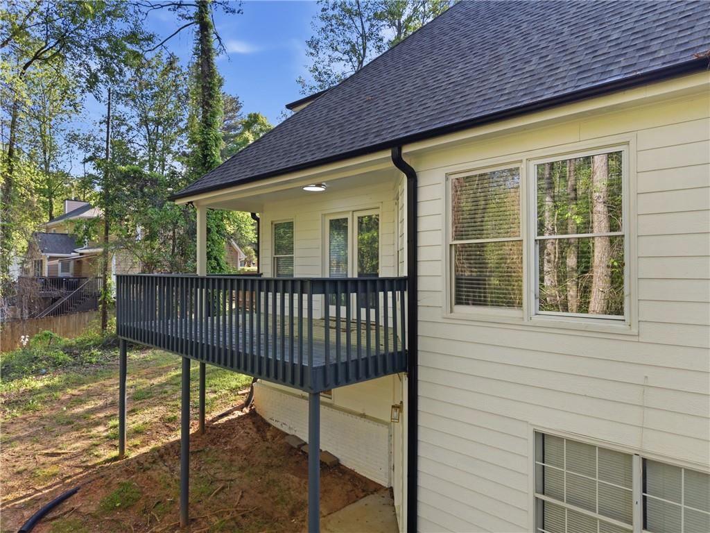 3760 Mountain Cove Road Snellville, GA 30039 - Photo 66 of 73 a view of a brick house with a wooden deck and a chair