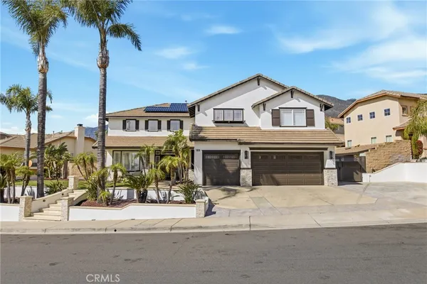 a view of a street sign and palm trees