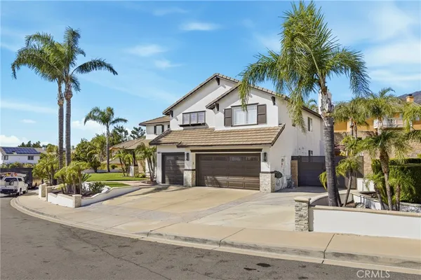 a front view of a house with palm trees