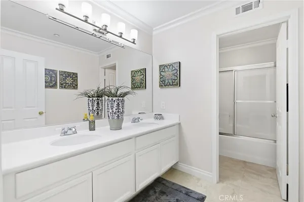 a bathroom with a double vanity sink and a mirror