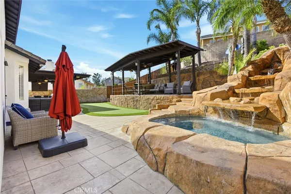 a view of a swimming pool with a lounge chair and palm trees