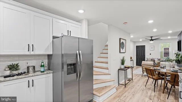 a kitchen with stainless steel appliances a refrigerator sink and white cabinets