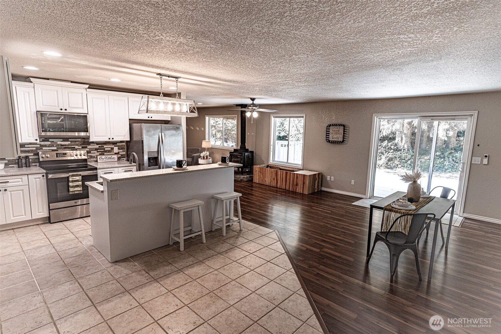 660 Peter Hagen Road West Seabeck, WA 98380 - Photo 18 of 39 a kitchen with stainless steel appliances kitchen island granite countertop a table chairs sink and cabinets