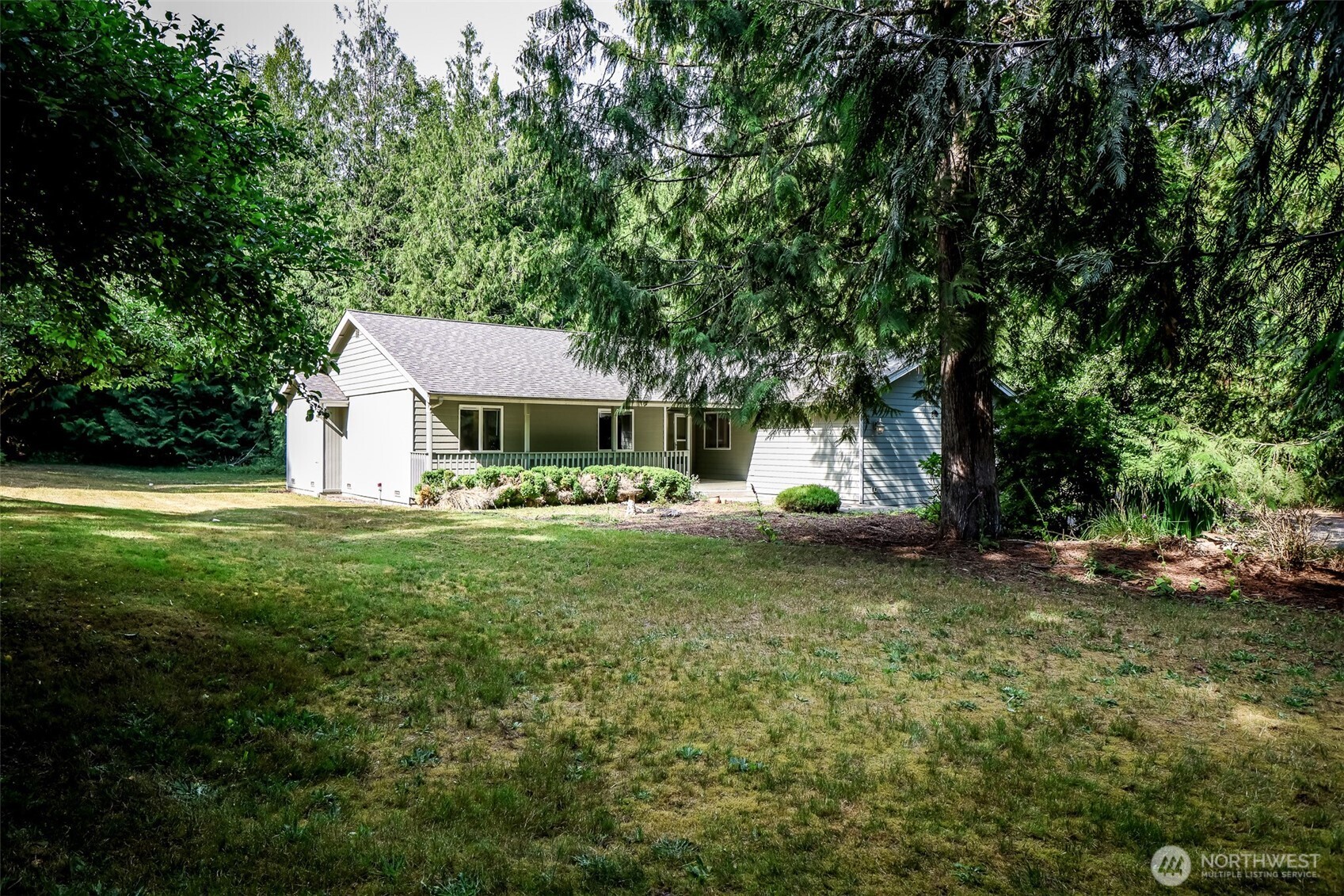 660 Peter Hagen Road West Seabeck, WA 98380 - Photo 6 of 39 a front view of a house with a yard garage and outdoor seating
