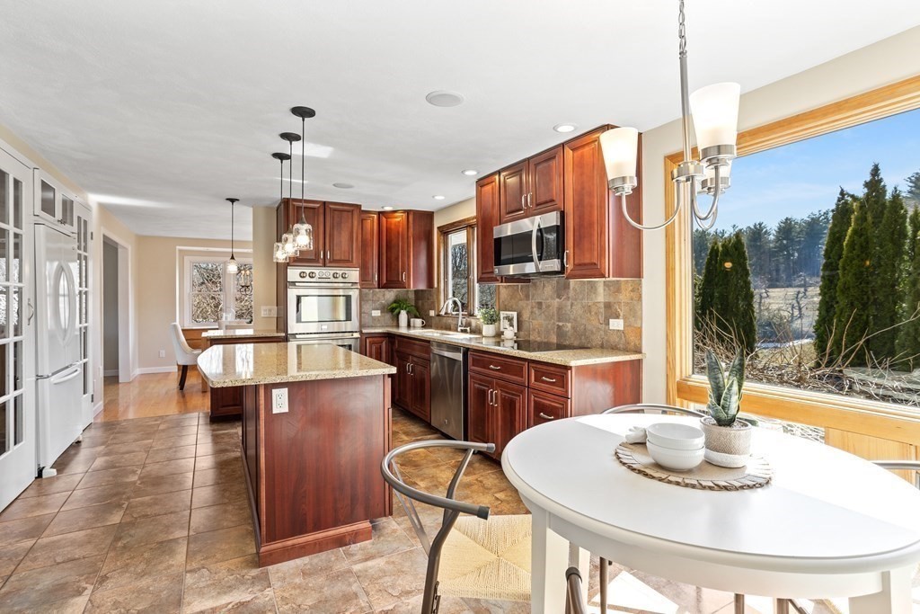 62 Westcott Road Harvard, MA 01451 - Photo 13 of 42 a kitchen with stainless steel appliances kitchen island granite countertop a table and chairs