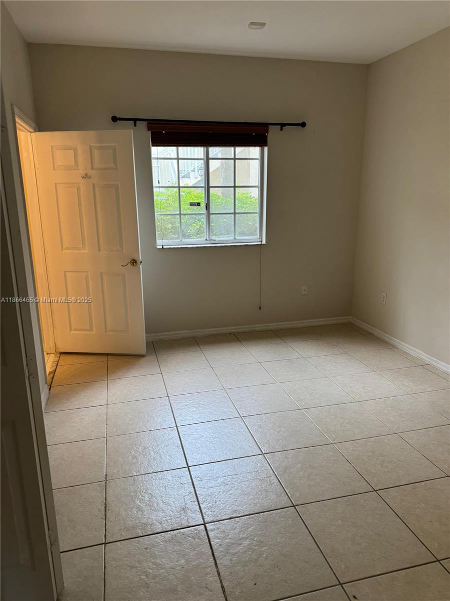 6922 Northwest 179th Street, Unit 1035 Hialeah, FL 33015 - Photo 12 of 14 an empty room with windows