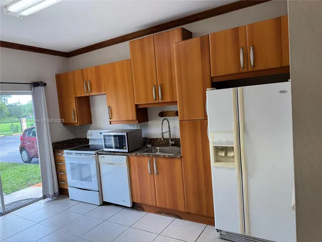 a kitchen with stainless steel appliances granite countertop a refrigerator and a stove top oven