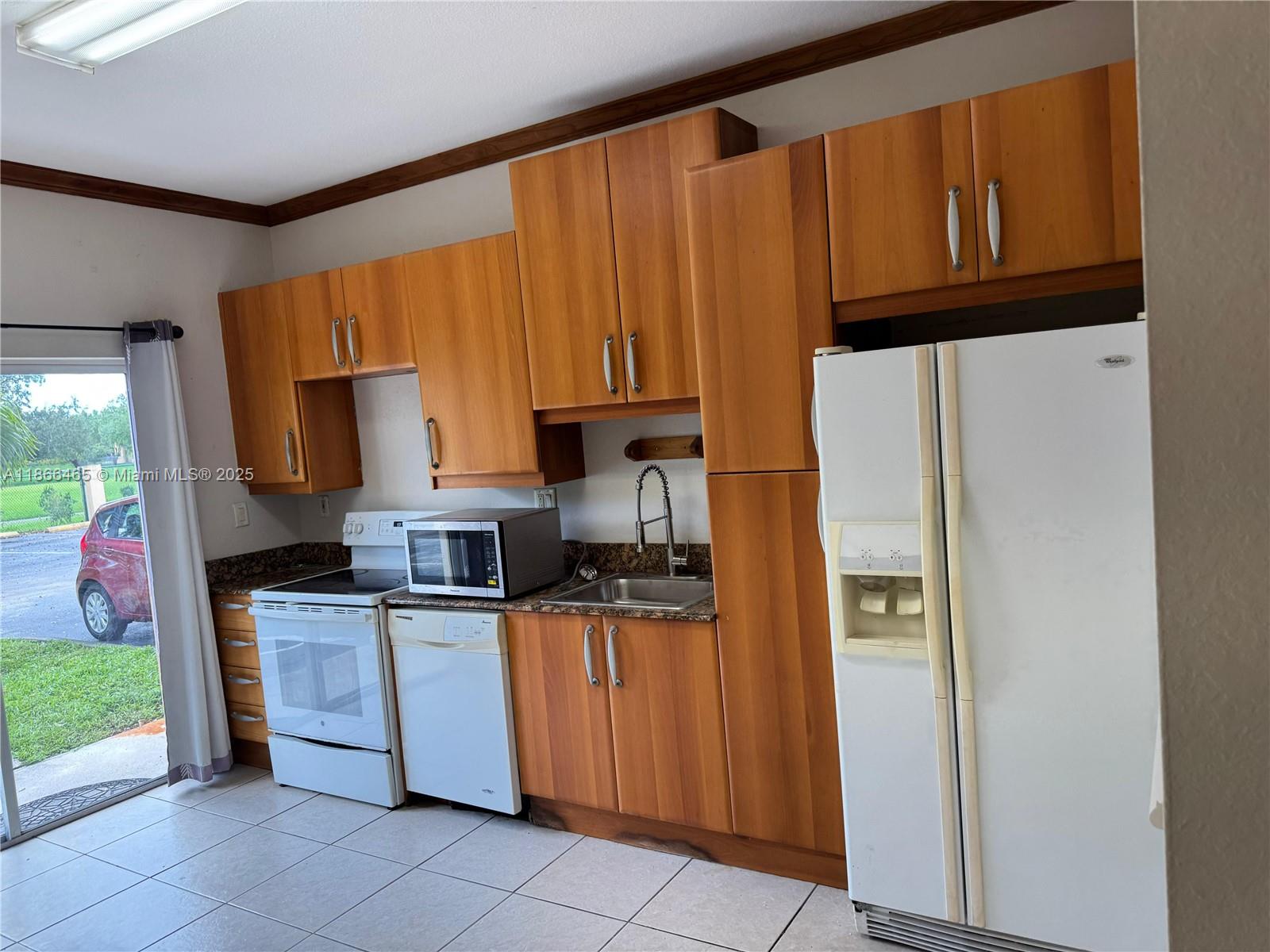 6922 Northwest 179th Street, Unit 1035 Hialeah, FL 33015 - Photo 2 of 14 a kitchen with stainless steel appliances granite countertop a refrigerator and a stove top oven