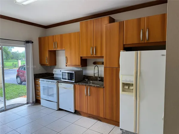 a kitchen with stainless steel appliances granite countertop a refrigerator sink and stove
