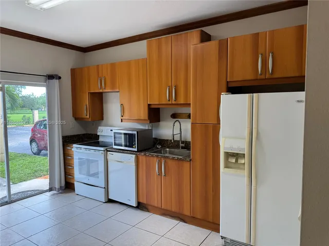 a kitchen with stainless steel appliances granite countertop a refrigerator sink and stove