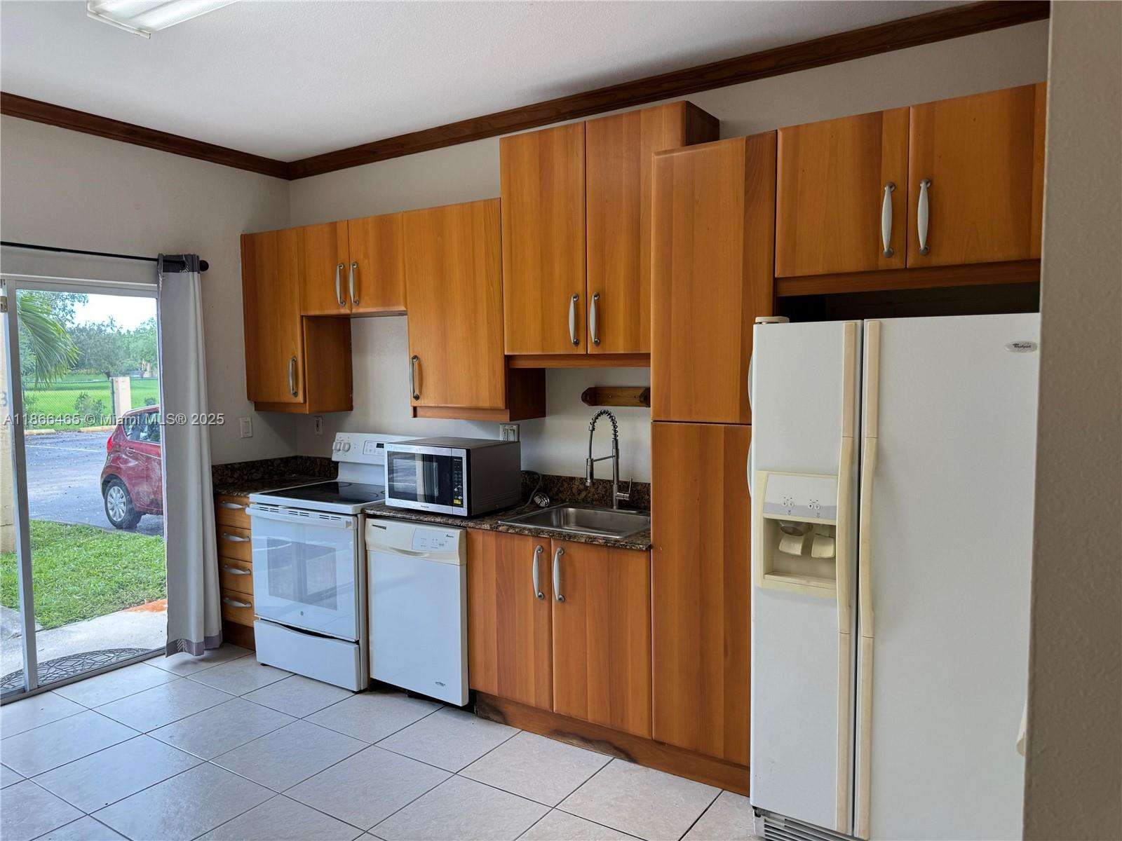 6922 Northwest 179th Street, Unit 1035 Hialeah, FL 33015 - Photo 3 of 14 a kitchen with stainless steel appliances granite countertop a refrigerator sink and stove