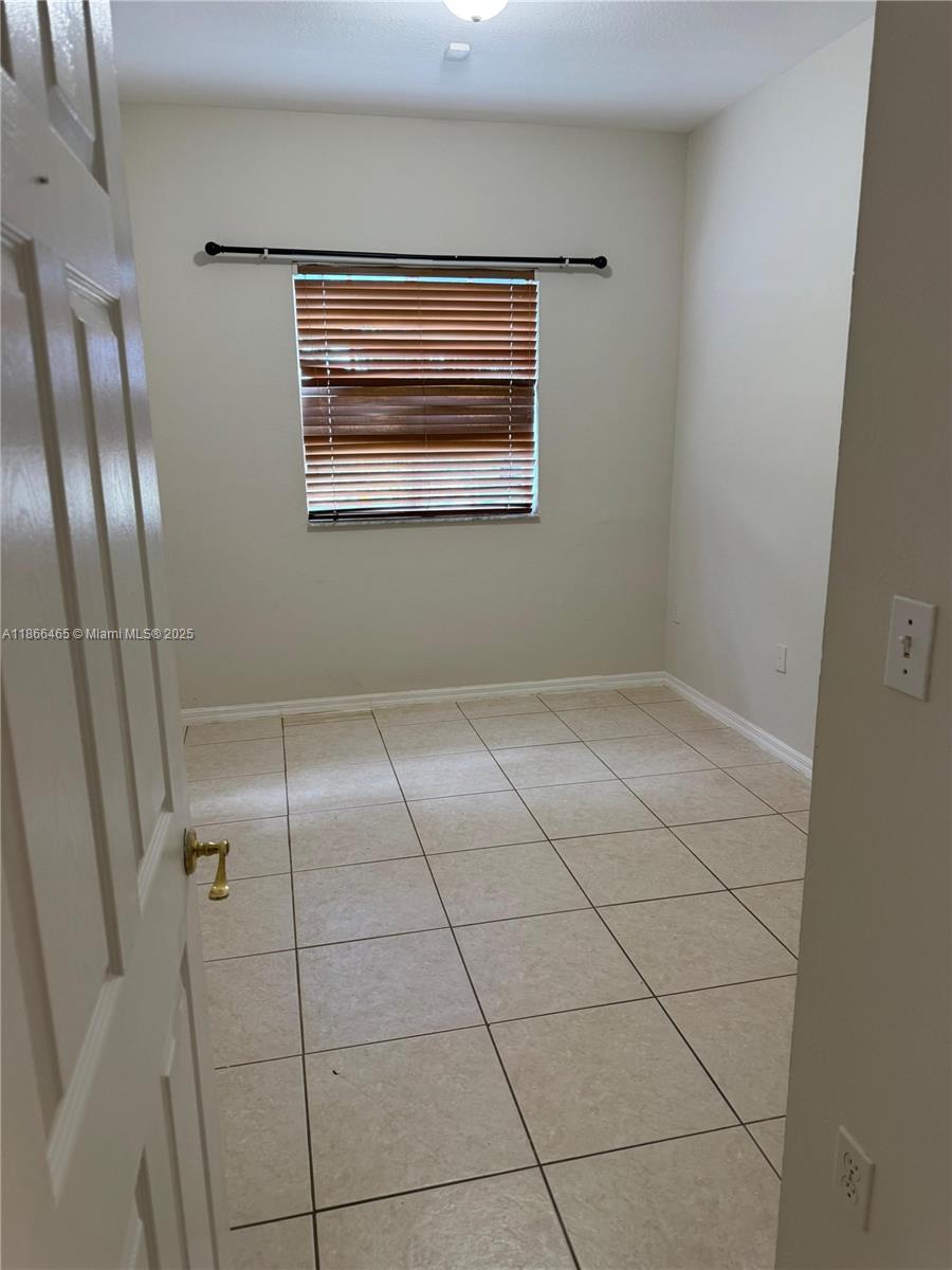 6922 Northwest 179th Street, Unit 1035 Hialeah, FL 33015 - Photo 6 of 14 a view of an empty room with a window