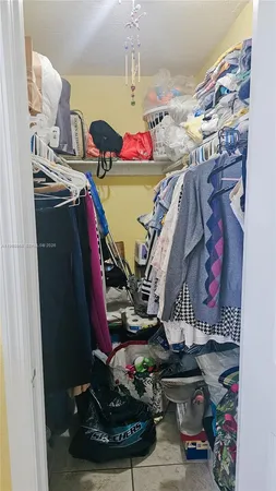 a view of walk in closet with clothes and shoes