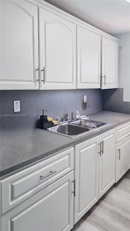 a kitchen with white cabinets and white appliances