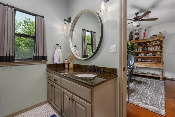 a bathroom with a granite countertop sink and a mirror