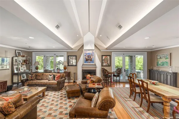 a living room with furniture a large window and wooden floor