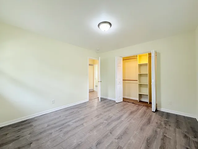 an empty room with wooden floor and a window