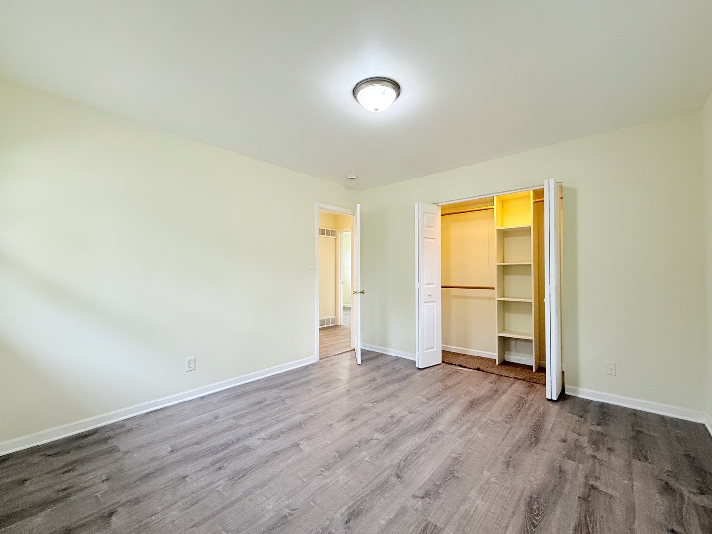 17511 Maple Avenue Lansing, IL 60438 - Photo 11 of 24 an empty room with wooden floor and a window