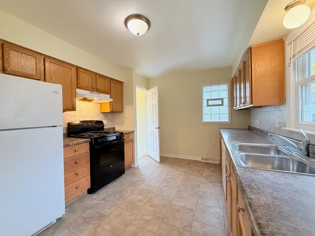 a kitchen with granite countertop a refrigerator stove and sink