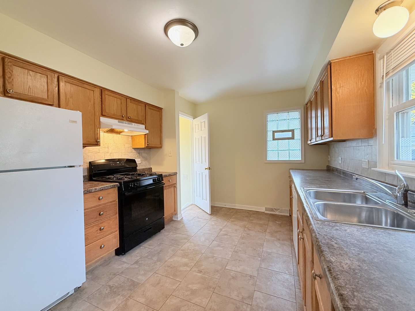 17511 Maple Avenue Lansing, IL 60438 - Photo 12 of 24 a kitchen with granite countertop a refrigerator stove and sink