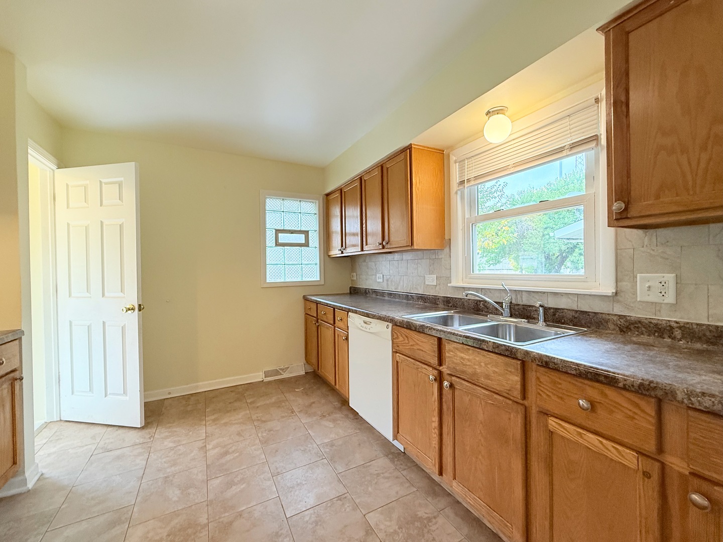 17511 Maple Avenue Lansing, IL 60438 - Photo 13 of 24 a kitchen with granite countertop a sink window and cabinets