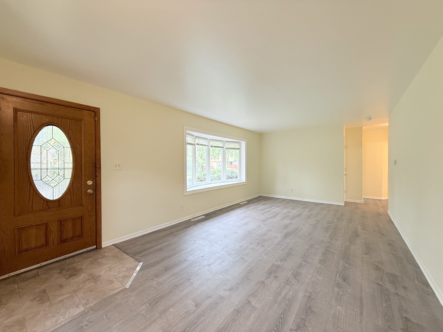 17511 Maple Avenue Lansing, IL 60438 - Photo 3 of 24 an empty room with wooden floor and windows