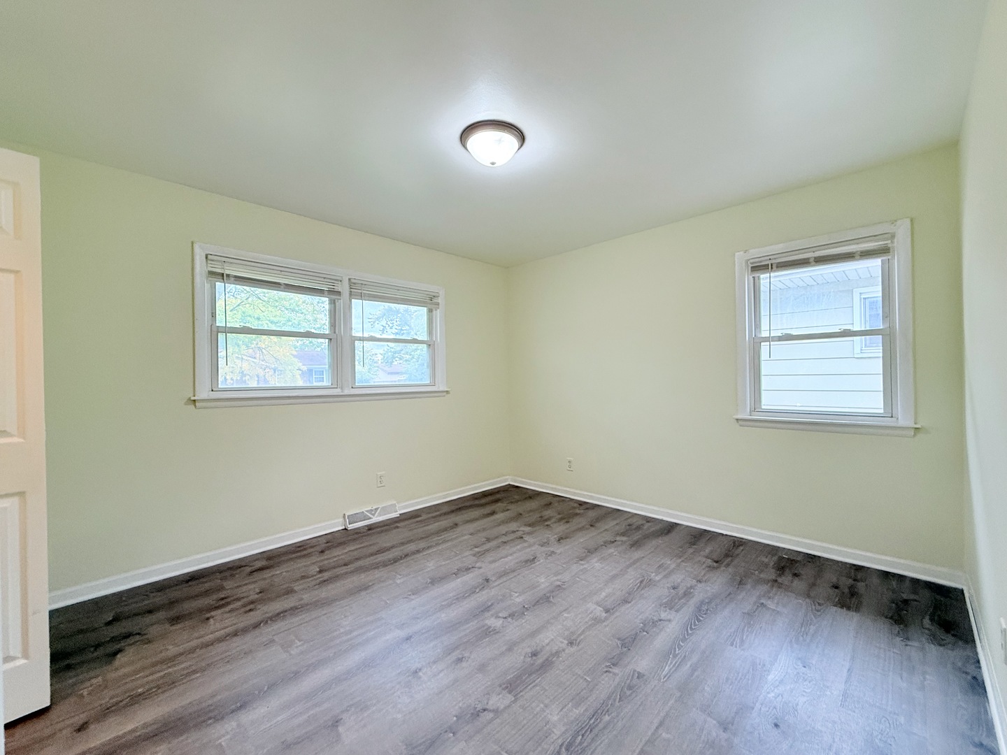 17511 Maple Avenue Lansing, IL 60438 - Photo 10 of 24 a view of an empty room with wooden floor and a window