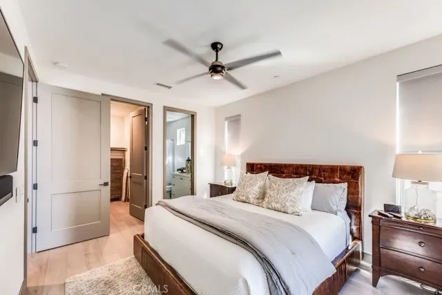 a bedroom with a large bed and a chandelier