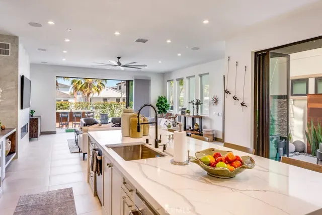 a kitchen with stainless steel appliances a sink a counter top space and living room view