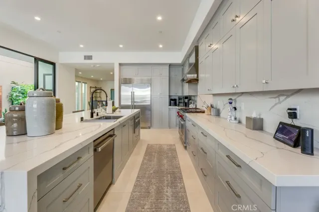 a large kitchen with stainless steel appliances lots of counter space and a sink