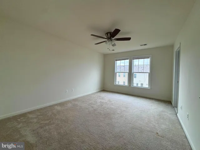 an empty room with a window and a ceiling fan