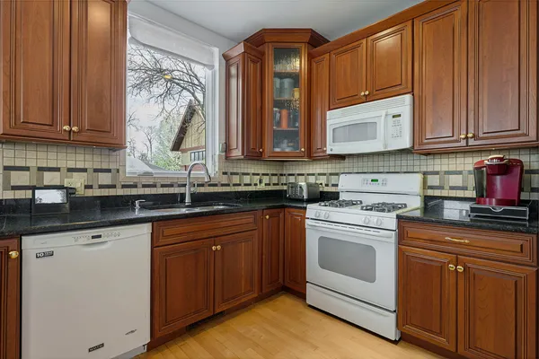 a kitchen with stainless steel appliances granite countertop a sink a stove and cabinets