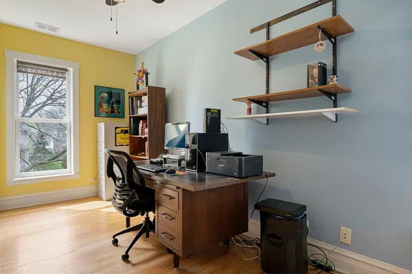 a view of a workspace with furniture and a window