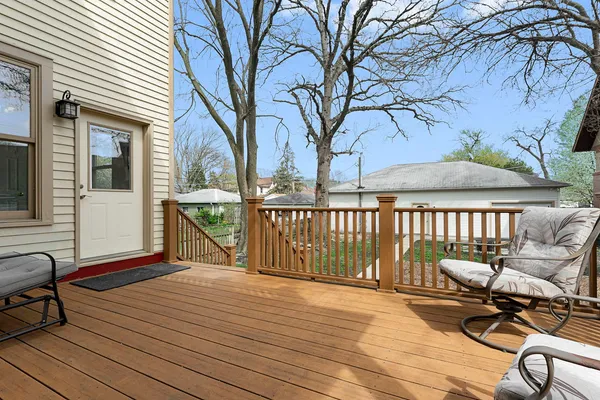 a balcony with wooden floor table and chairs