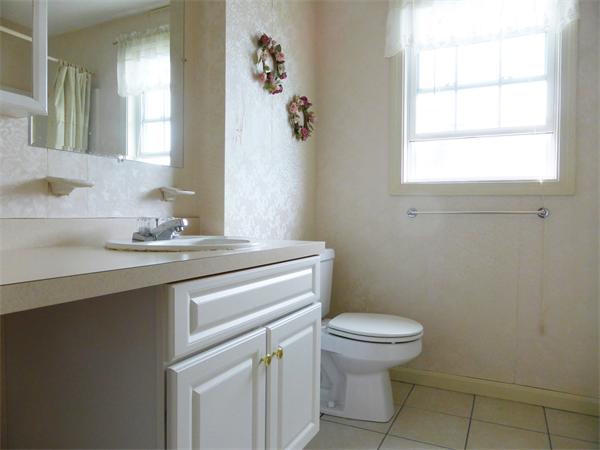 985 Trapelo Road, Unit 4 Waltham, MA 02452 - Photo 8 of 10 a bathroom with a granite countertop sink a toilet and a mirror