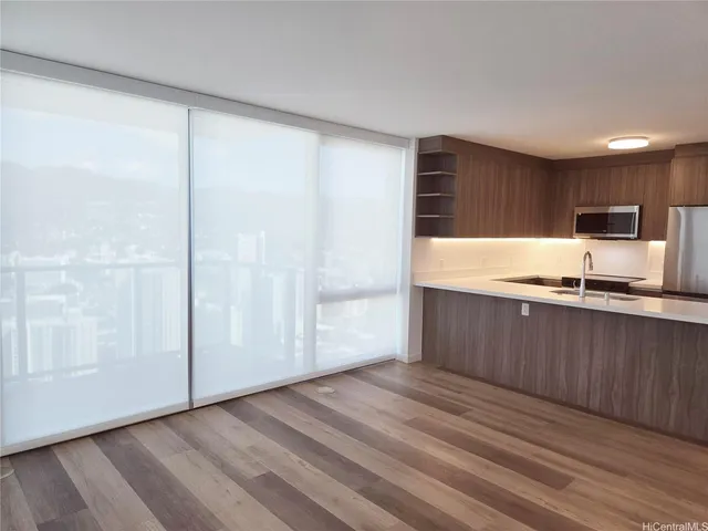 a kitchen with granite countertop a refrigerator and a stove top oven