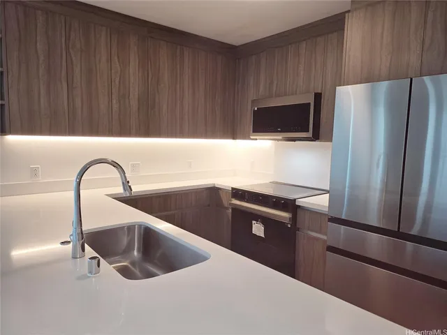 a kitchen with granite countertop a refrigerator and a sink