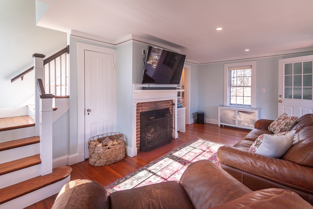 94 Atlantic Avenue, Unit 1 Cohasset, MA 02025 - Photo 9 of 23 a living room with furniture a flat screen tv and a fireplace