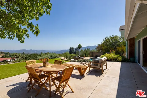 a view of a patio with table and chairs and potted plants