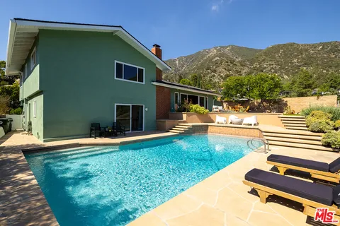 a view of swimming pool with a yard and mountain view