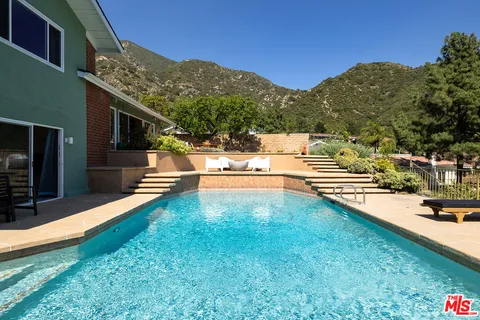a view of a house with pool and a yard