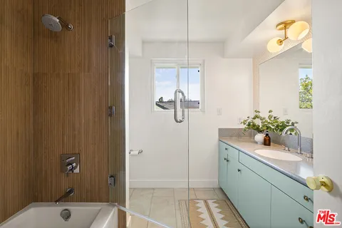 a bathroom with a shower sink and mirror