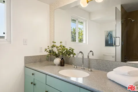 a bathroom with a granite countertop sink and a mirror