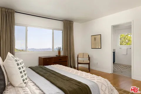 a bedroom with a bed and a large window