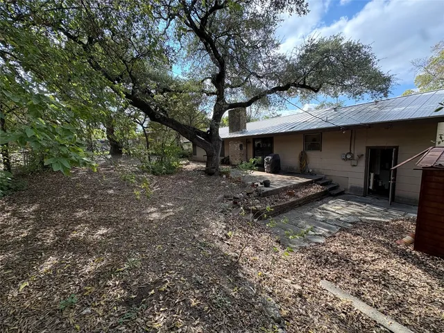 a backyard of a house with barbeque oven table and chairs