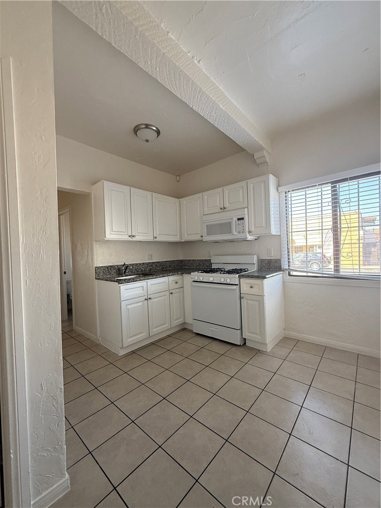 2012 East 7th Street, Unit A Long Beach, CA 90804 - Photo 1 of 1 a kitchen with cabinets and white appliances